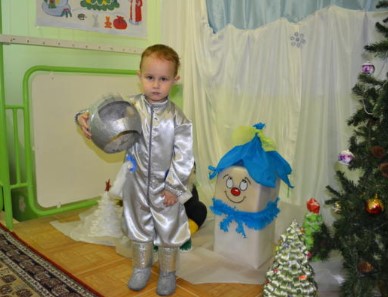 Костюм космонавта серебристый на ребенке возле новогодней елки